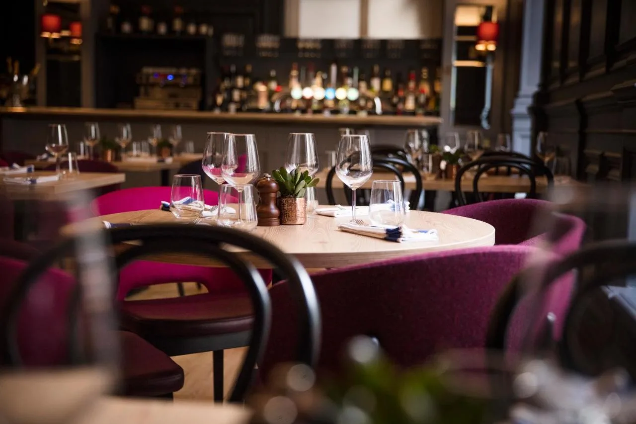 a table in a restaurant with wine glasses on it at The Clermont London, Victoria in London